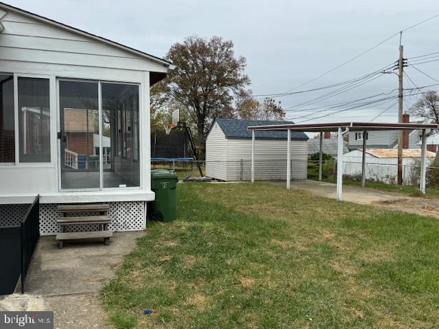 view of yard with a trampoline and a sunroom