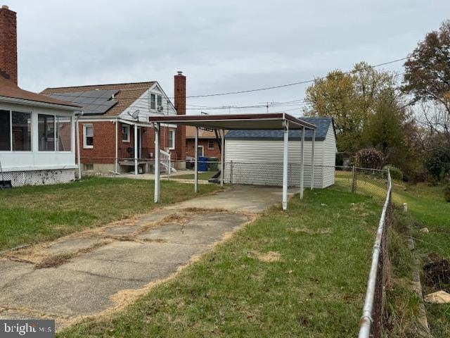 back of house with a lawn and a carport