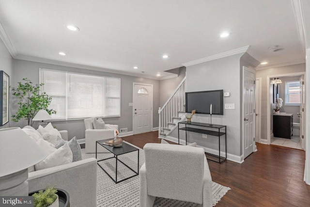 living room with a healthy amount of sunlight, dark hardwood / wood-style flooring, and crown molding