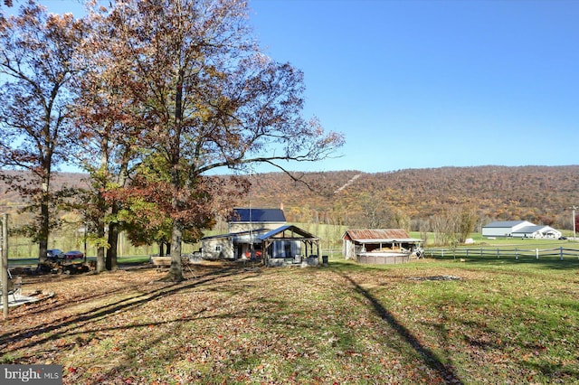 view of yard with a mountain view, a rural view, and an outbuilding