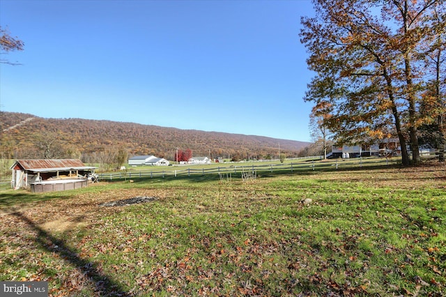 view of yard with a mountain view, a rural view, and an outdoor structure