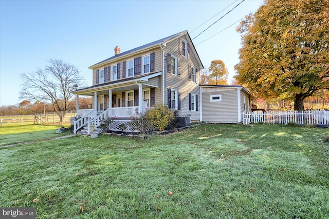 view of front of home featuring central AC, covered porch, and a front yard