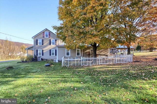 view of front of property with cooling unit and a front yard