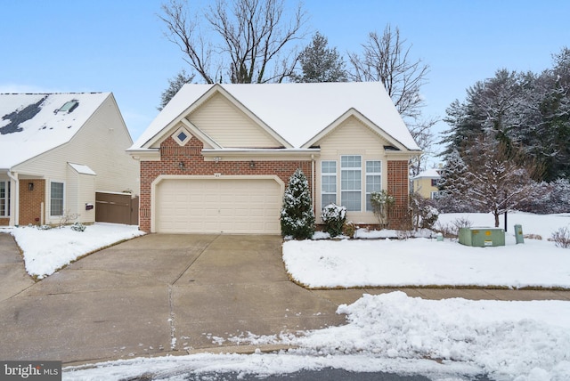 view of front of property with brick siding, driveway, and a garage