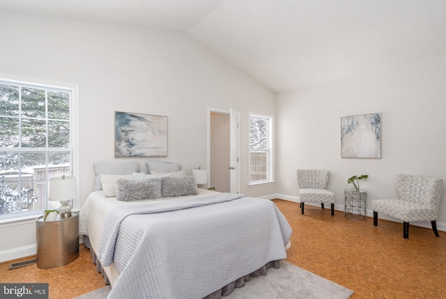 bedroom featuring multiple windows and high vaulted ceiling