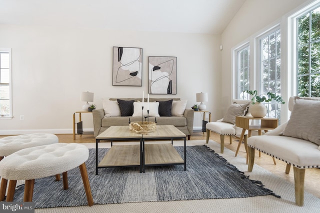 living room featuring hardwood / wood-style flooring, plenty of natural light, and vaulted ceiling