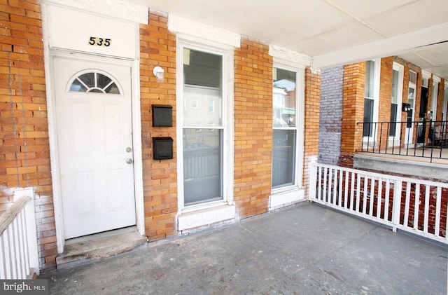 view of exterior entry featuring covered porch