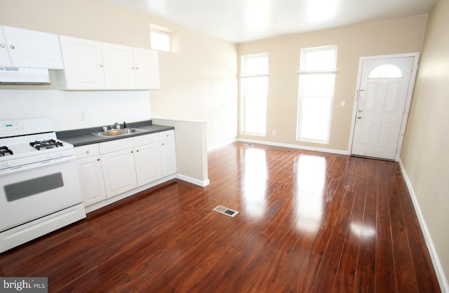 kitchen with sink, dark hardwood / wood-style flooring, white cabinets, exhaust hood, and white stove