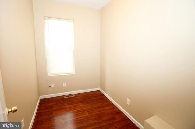 unfurnished room with dark wood-type flooring