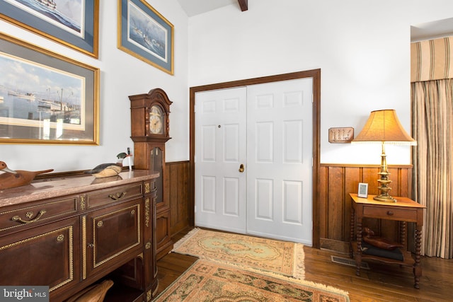 entryway with wooden walls and dark wood-type flooring