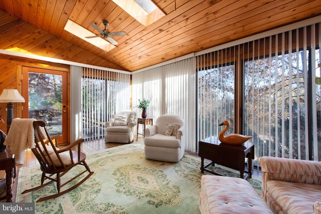 sunroom / solarium featuring ceiling fan, lofted ceiling with skylight, and wood ceiling