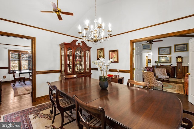 dining area featuring high vaulted ceiling, wood-type flooring, and ceiling fan with notable chandelier