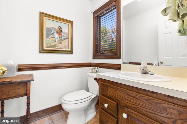 bathroom with toilet, vanity, and tile patterned floors