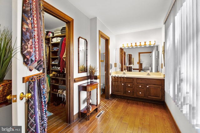 bathroom with wood-type flooring, vanity, and toilet