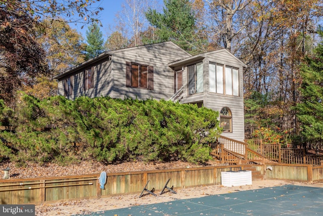 view of front of property featuring a covered pool and a sunroom