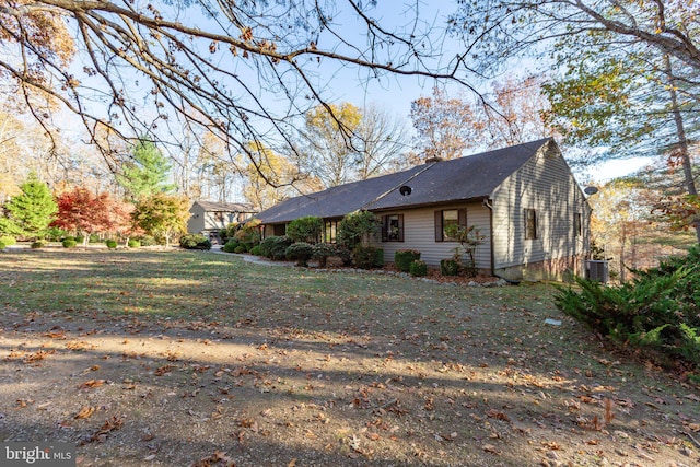 view of side of home with a yard and central AC