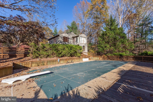 view of swimming pool with a diving board and a wooden deck