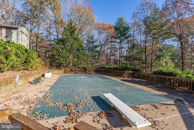 view of pool with a diving board