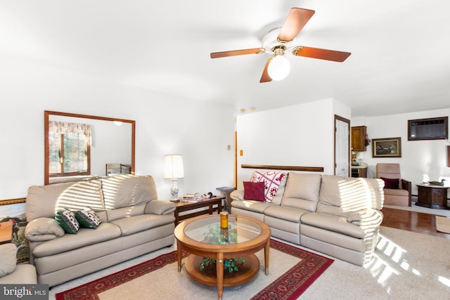 carpeted living room featuring a wall mounted air conditioner and ceiling fan