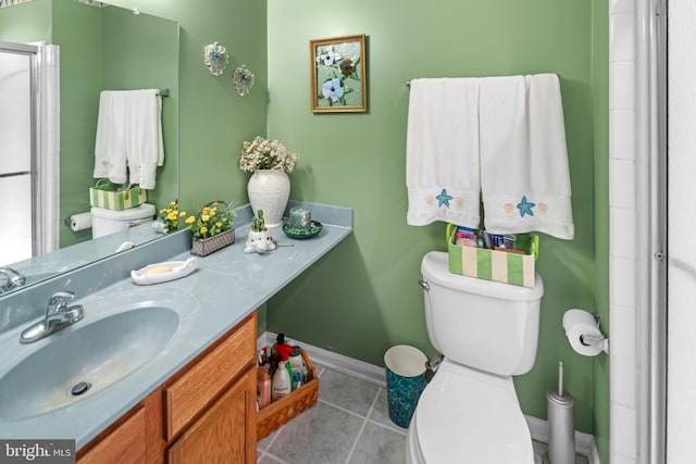 bathroom with toilet, vanity, tile patterned floors, and walk in shower