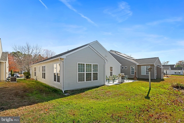 back of property with a yard and a patio