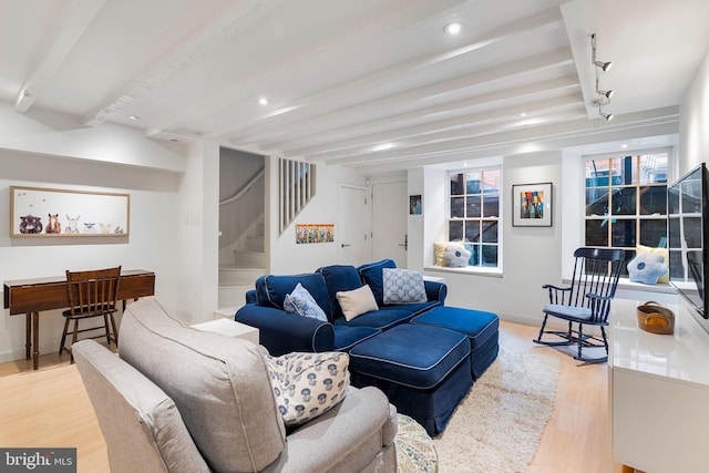 living room with track lighting, light wood-type flooring, and beamed ceiling