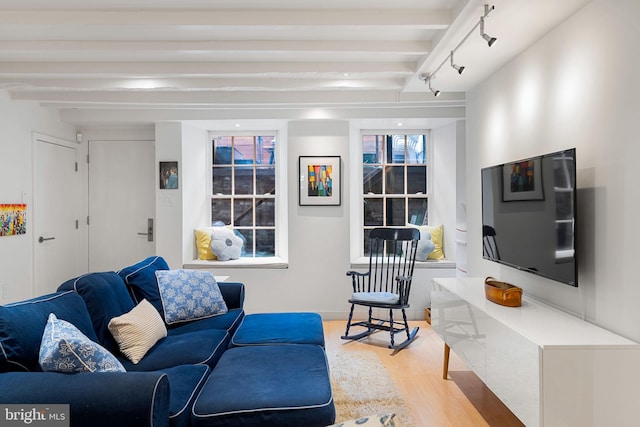 living room featuring beam ceiling, light hardwood / wood-style floors, and rail lighting