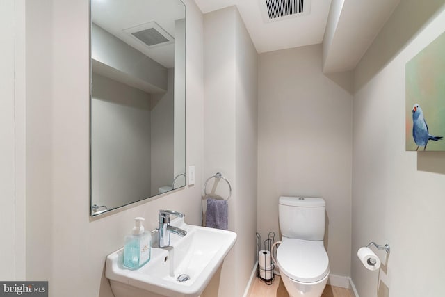 bathroom featuring toilet, hardwood / wood-style flooring, and sink