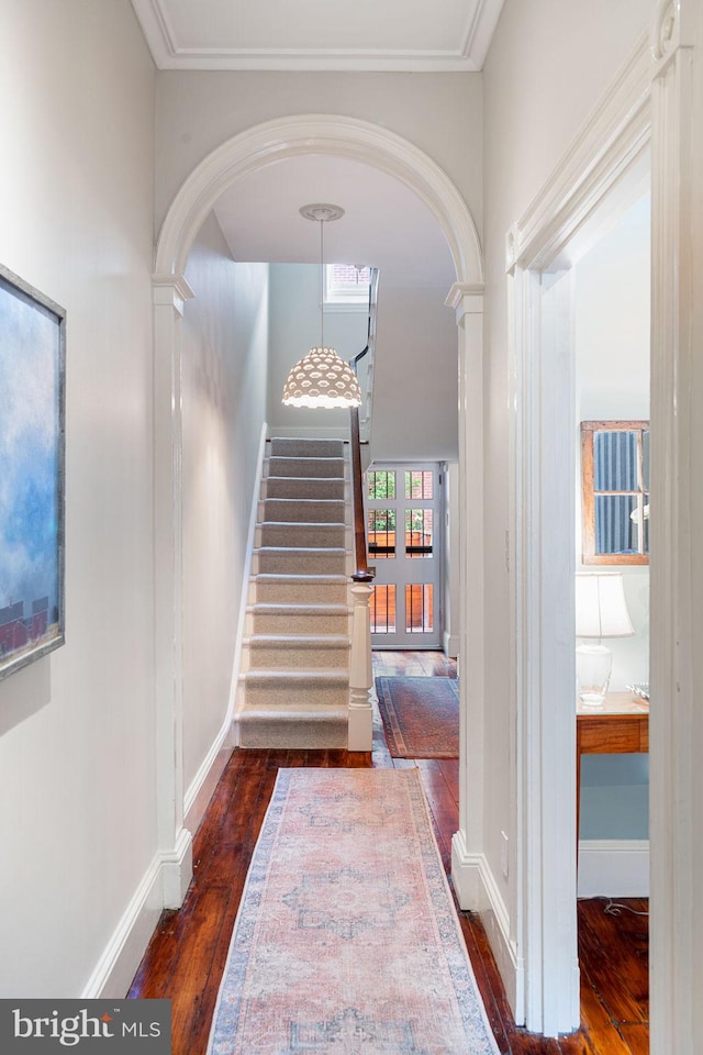 hallway with dark wood-type flooring and decorative columns