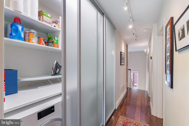 corridor with dark hardwood / wood-style flooring and rail lighting