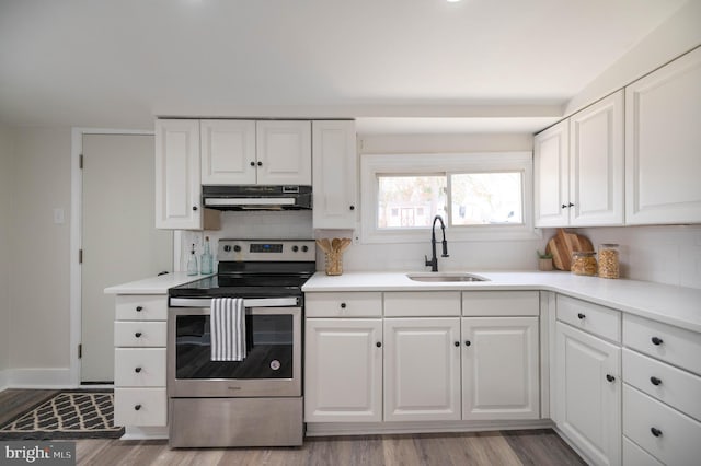 kitchen with backsplash, stainless steel range with electric stovetop, sink, light hardwood / wood-style flooring, and white cabinetry