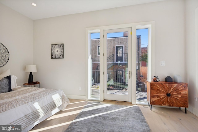 bedroom with light wood-type flooring and access to outside