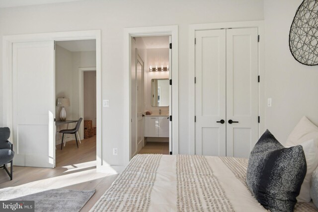 bedroom featuring ensuite bathroom, light hardwood / wood-style floors, and a closet