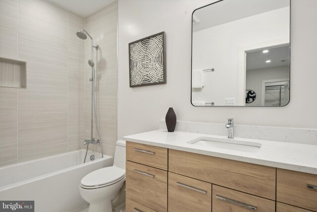 full bathroom featuring vanity, toilet, and tiled shower / bath combo