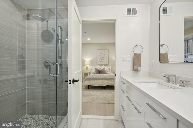 bathroom with wood-type flooring, vanity, and an enclosed shower