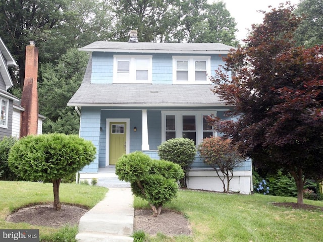 view of front of home featuring covered porch and a front lawn