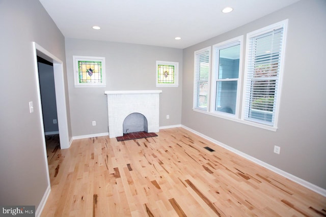 unfurnished living room featuring light hardwood / wood-style floors and a fireplace