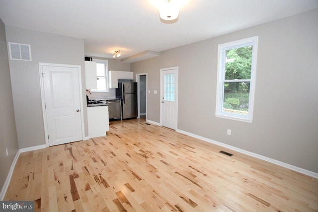 kitchen featuring white cabinetry, stainless steel appliances, and light hardwood / wood-style flooring