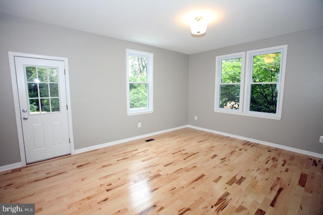 unfurnished room with plenty of natural light and light hardwood / wood-style floors