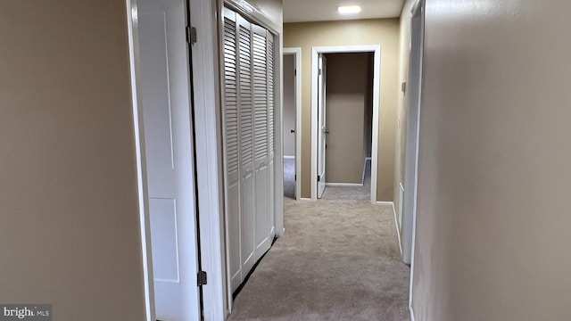 hallway featuring light colored carpet