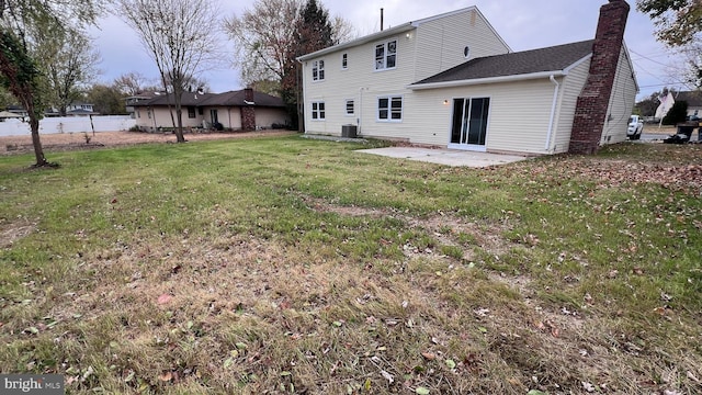 back of house with a lawn, central air condition unit, and a patio