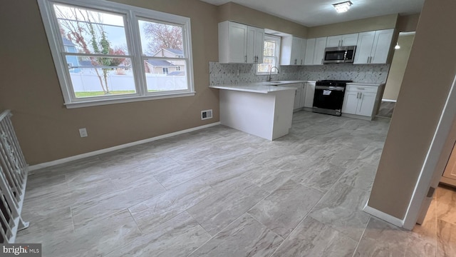 kitchen with white cabinetry, a wealth of natural light, and stainless steel appliances