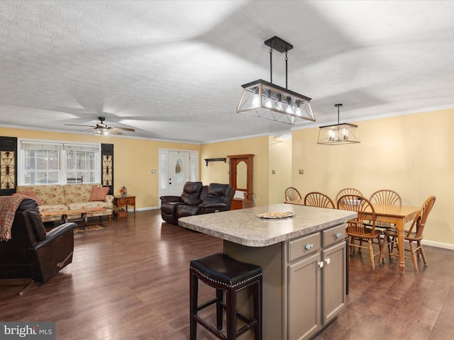 kitchen with ceiling fan, a center island, dark hardwood / wood-style flooring, decorative light fixtures, and gray cabinets