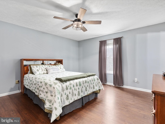 bedroom with a textured ceiling, dark hardwood / wood-style floors, and ceiling fan