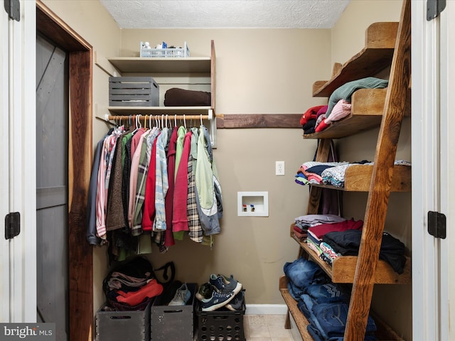 spacious closet with light tile patterned floors