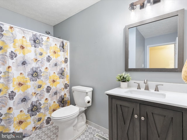 bathroom with a shower with shower curtain, vanity, a textured ceiling, tile patterned flooring, and toilet