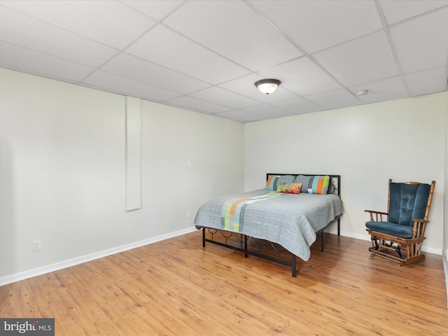 bedroom featuring a paneled ceiling and hardwood / wood-style flooring