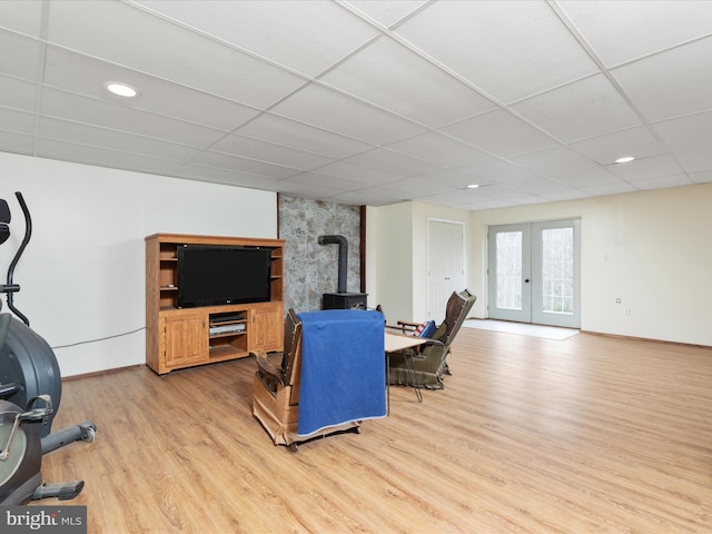 living room featuring french doors, light hardwood / wood-style floors, and a drop ceiling