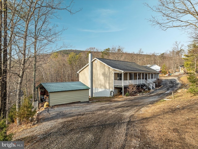 view of home's exterior featuring a porch and an outbuilding