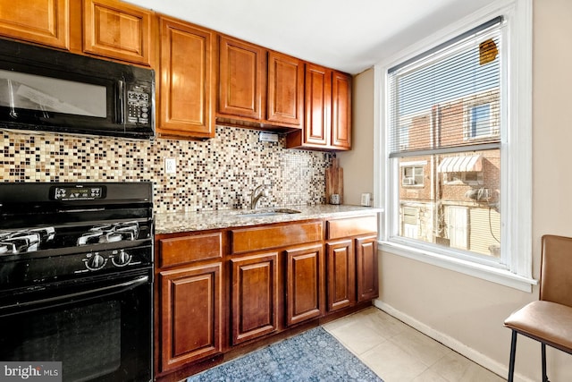 kitchen with black appliances, light tile patterned floors, light stone counters, and tasteful backsplash